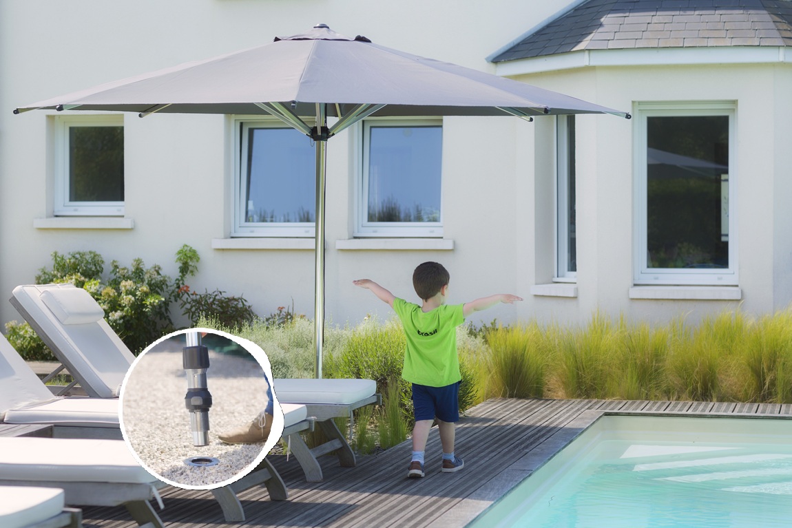 Sombra de un parasol recto sobre una tumbona junto a la piscina